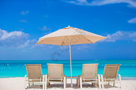 热带海滩的白色雨伞和防晒床晴天支撑旅游海岸异国旅行海洋酒店椅子气候图片