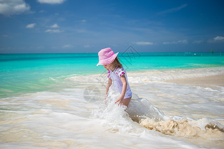 可爱的幼儿女孩在异国海滩浅水中玩耍旅游海岸线女士海洋情调女儿热带草帽海景太阳图片