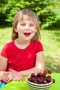 儿童吃野樱桃盘子甜点金发女郎童年享受桌子午餐女孩水果红宝石图片