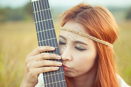 在草地上弹吉他的嬉皮女孩文化吉他手乐器自由青少年音乐家国家吉他女士女性图片