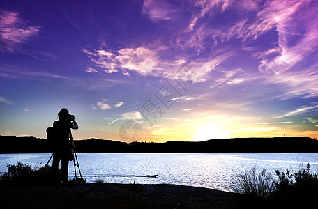 夕阳海日落时 摄影师随其设备一起拍摄的轮光片背景