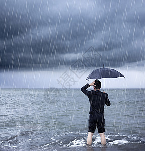 心烦意乱的商务人士拿着有云暴背景的雨伞图片