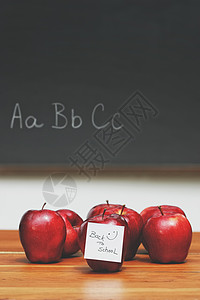 桌上有纸条的苹果 背景是黑板背景图片