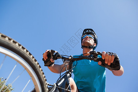 在国道上骑脚踏车的赛车运动员活动骑术蓝天闲暇自行车农村冒险越野男性山地图片