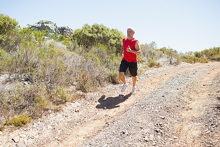 健壮的人在山下慢跑踪迹竞技运动农村环境训练娱乐活动风景晴天图片