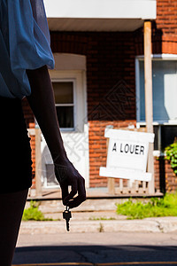 青年女子站在她新公寓前的前面房地产房子住宅财产金发女郎钥匙标志家庭兜帽抵押图片