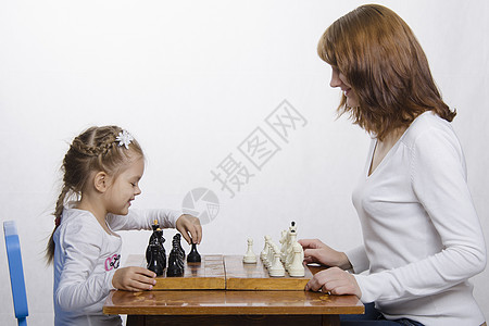 妈妈教女儿下国际象棋学习母亲典当家庭爱好幸福职业骑士乐趣图片
