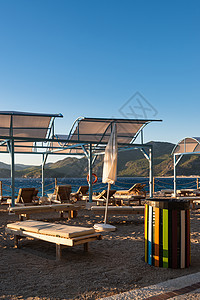 沙滩上有雨伞的太阳休息者假期旅游躺椅阴影旅行火鸡遮阳棚晴天热带休息室图片