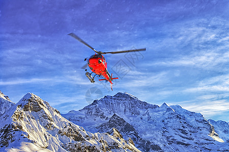 冬季附近的红直升机在天空中高山喷发图片