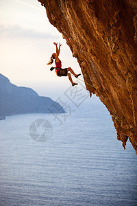 女性攀岩者倒在悬崖上挑战勇气安全女士岩石风险成人登山者失败绳索图片