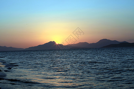 爱琴海日落天气蓝色纹理海洋地平线太阳海浪假期反射射线图片