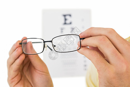 为阅读眼科测试而佩戴的眼镜黑色图表配镜师白色光学双手信件图片