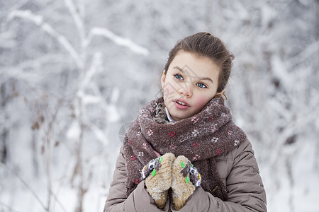 快乐的小女孩 在冬季公园的背景背景中微笑女孩针织雪堆冬装小姑娘夹克孩子衣服帽子图片