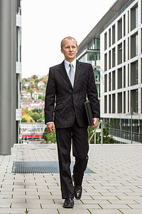 在户外穿黑西装的 笑着微笑的成功商务人士幸福经理城市领带银行业工人老板男性办公室工作图片