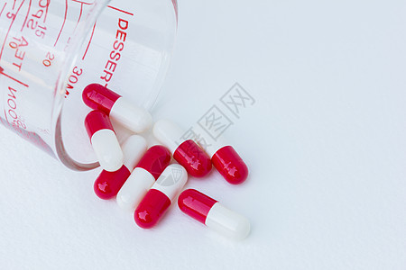 红色药片白色后腹骨上玻璃中的白红胶囊药组药片治愈医疗宏观处方药店瓶子治疗技术科学背景