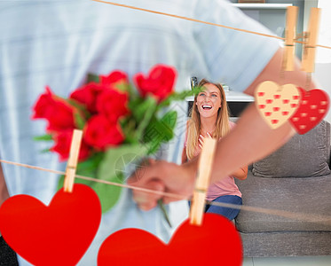 男人在沙发上藏着一束玫瑰花 从笑笑的女友身上感情微笑夫妻男性惊喜木桩客厅绳索公寓玫瑰图片