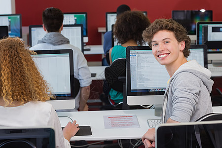 学生在电脑课上对着镜头微笑男性大学电脑显示器电脑室知识班级潮人学习设计师课堂图片