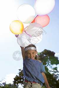 蓝天气球快乐的小女孩拿着气球阳光童年公园闲暇自由蓝天男性树木微笑绿地背景