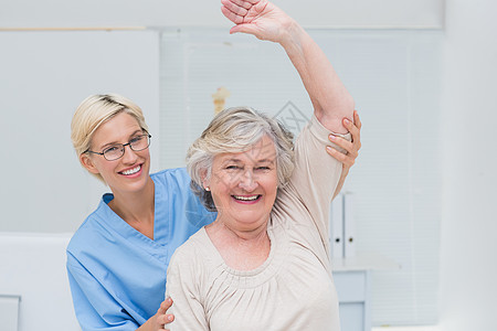 高级病人在护士帮助下举臂扶助图片