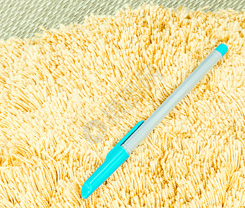 蓝笔在橙色毛发布地毯上铅笔白色毛皮宏观头发蓝色粉色柔软度材料纤维图片