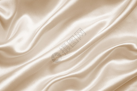 平滑优雅的金色丝绸或西边纹理作为背景材料婚礼新娘棕褐色涟漪海浪调子织物投标窗帘背景图片