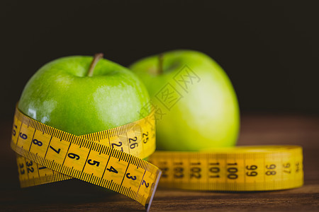 绿色苹果和测量磁带饮食桌子减肥木头营养瘦身健康饮食卷尺体育锻炼背景图片