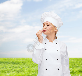 微笑的女厨师露出美味的标志管理人员食物女孩天空面包师餐厅帽子蓝色手势工作图片