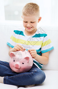 带着小猪银行和钱 笑着笑着的小男孩奖金财富推杆微笑童年房间银行投资口袋硬币图片