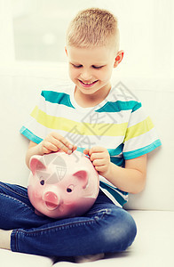 带着小猪银行和钱 笑着笑着的小男孩小猪银行业微笑推杆幸福收集储蓄口袋货币孩子图片