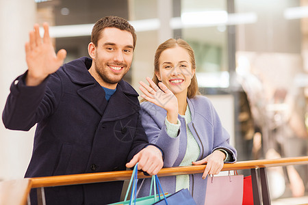 你好同学快乐的年轻夫妇和购物商场购物袋消费者恶魔手势女士销售中心男人女朋友零售礼物背景