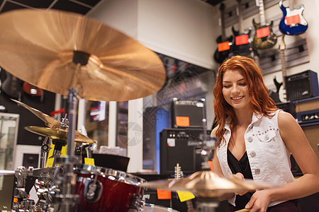 在音乐店玩琴的笑着微笑的音乐家推销员店铺销售助手乐器仪器女性齿轮顾客消费者图片