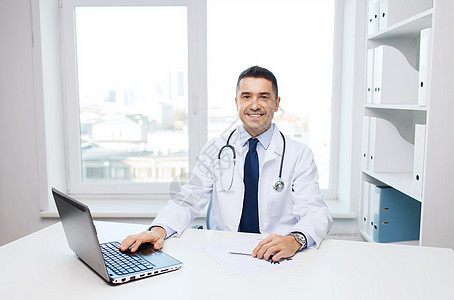 男医生在医疗办公室用膝上型笔记本电脑医院互联网药品帮助工作保健从业者医师心脏病诊所图片
