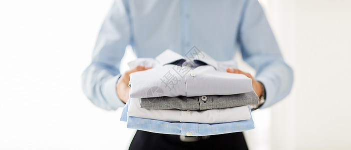 近身的商务人士拿着折叠的衬衣洗衣店男性衣柜棉布服装男人衬衫商业家务纺织品图片