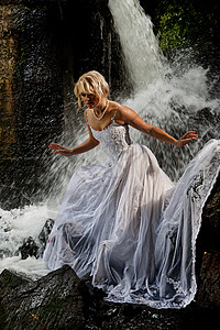 A河上的年轻新娘溪流节日石头感性吸引力瀑布金发女郎赤脚裙子泡沫图片