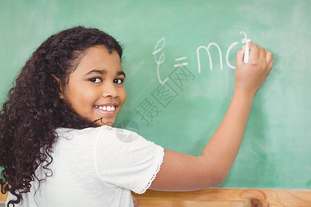 微笑的学生在教室的黑板上写字知识学校数学早教科学女孩快乐混血课堂女性图片
