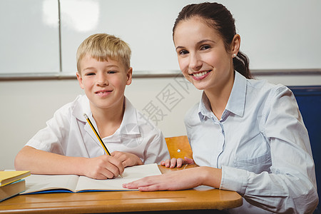 国外小学生帮助班级学生的教师教学老师女士学校桌子知识学习男性早教女性背景