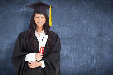 以毕业礼服着装的女性综合形象与学位相融合的女模样混血黑色长袍快乐蓝色黑板成就流苏黑发微笑图片