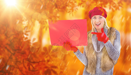 穿着红色标志的冬衣金发美女综合图象手指手势橙子林地森林冬装休闲金子衣物广告图片