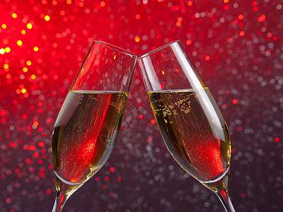 一对香槟笛子 红色和紫色浅光布基背景的金泡图片