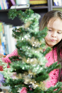 装饰圣诞树的小女孩女性孩子童年庆典微笑亚裔混血装潢女孩假期图片