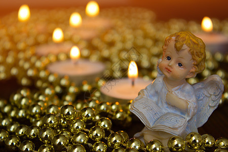 圣诞天使在蜡烛背景的圣诞天使天使玻璃装饰星星桌子装饰品假期钟声灯光季节图片