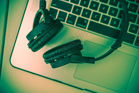 耳机和笔记本电脑扬声器互联网工作喇叭键盘绿色音乐家水平蓝牙技术图片