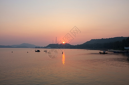 日落后海滩码头的海和山海岸假期丘陵热带天空旅行支撑港口环境太阳图片