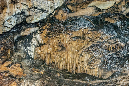 拉比沙村附近的马古拉洞穴内岩层形成红色土地黄色流动石头洞穴灰色奶油石笋钟乳石图片