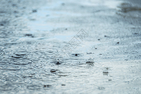 超慢运动中的雨滴水坑中的雨滴下雨运动环境流动同心水滴海浪圆圈液体蓝色背景