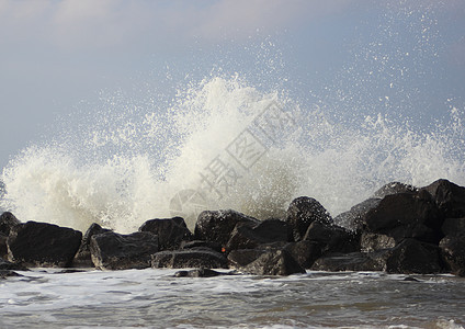 海岸对黑岩石的撞击波浪荒野石头风暴激流海洋水滴盐水蓝色支撑液体图片