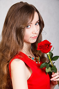 一位年轻有魅力的红玫瑰女士的特写肖像图片