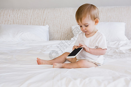 使用智能手机的可爱婴儿技术住所男性公寓坐垫家庭生活枕头男生房子家庭图片