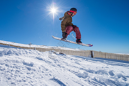 滑雪机跳过蓝天青少年单板骑术滑雪速度便车岩石男人娱乐滑雪板图片