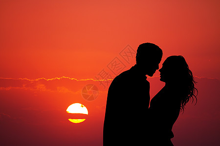 日落时一对夫妇接吻恋人女士红色阳光男人闲暇插图庆典图片